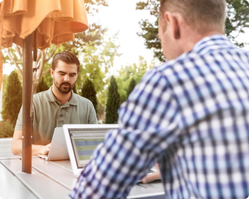  two white men using their laptops